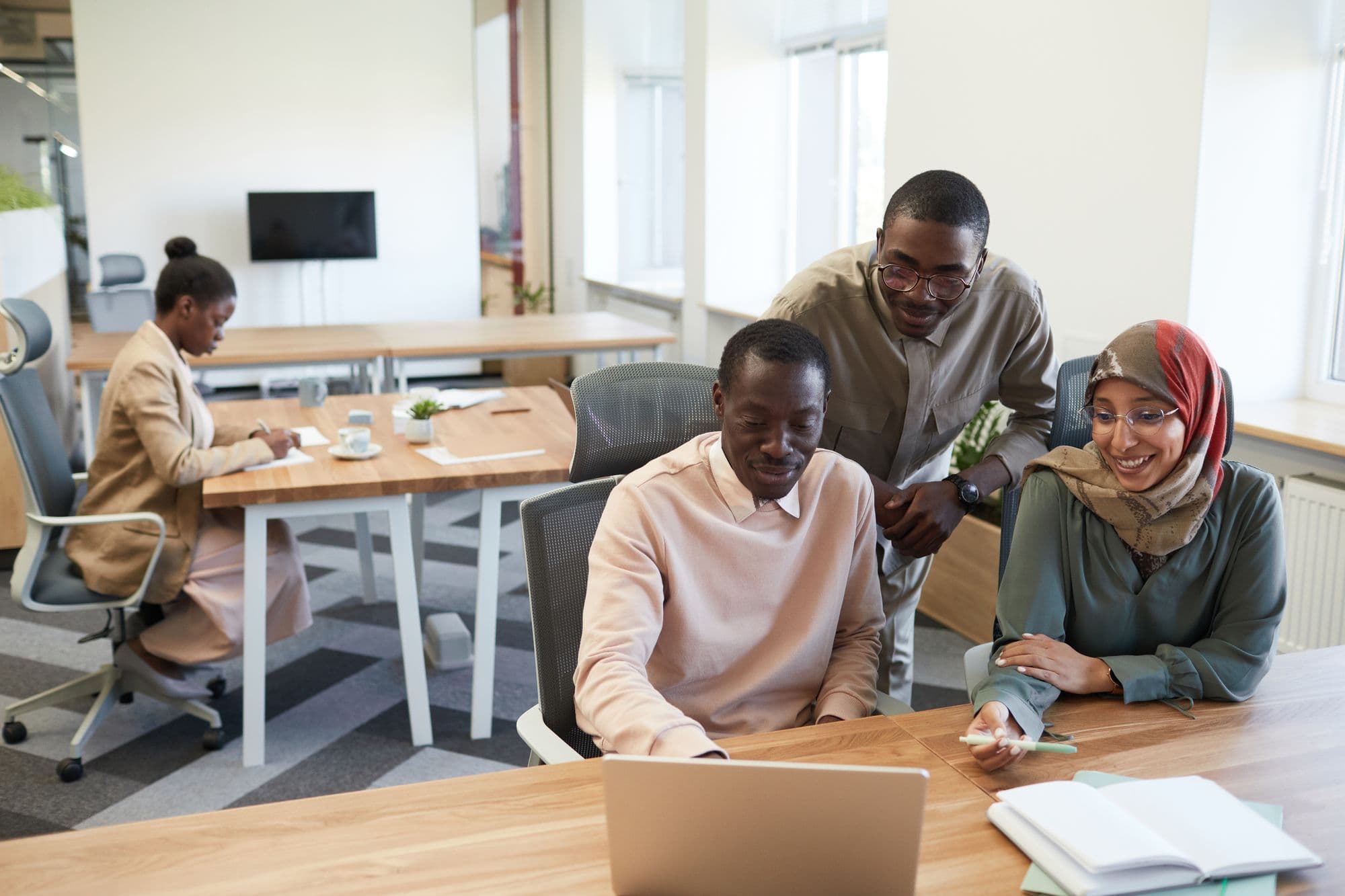 A team working together at laptops around an office table